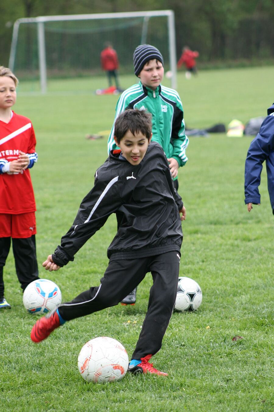 Junge schießt beim Training einen Ball